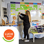 Collaboratrice devant le tableau des engagements RSE, label Lucie 26000