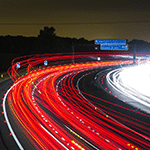 Traînées lumineuses de voitures sur une autoroute de nuit