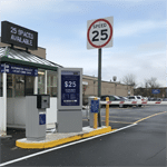 Entrée de parking avec panneau de vitesse 25 et totem de tarifs