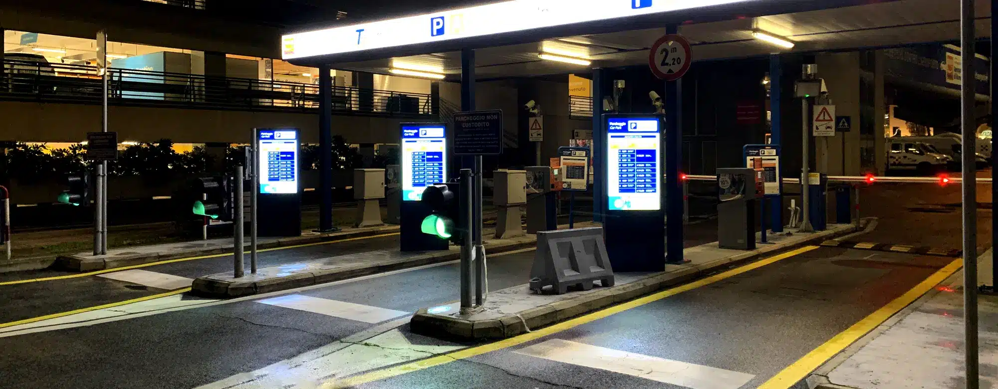 Totems d'affichage dynamique aux barrières d'entrée d'un parking, de nuit