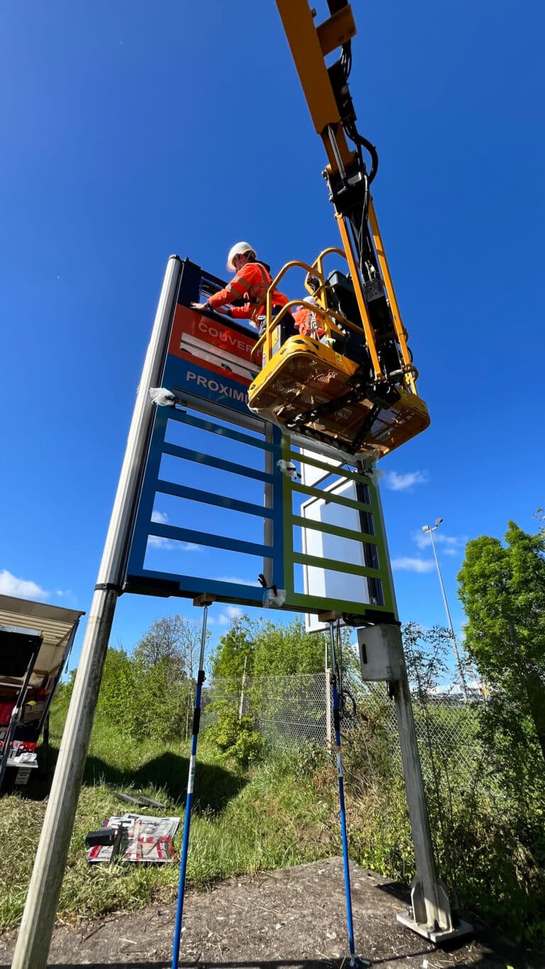 Technicien en nacelle sur la structure d'un panneau de jalonnement